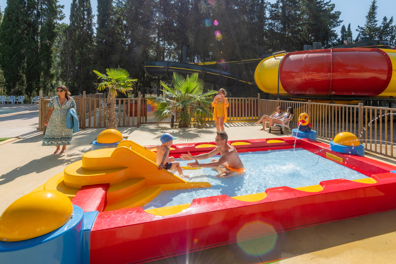 Children's pool with slide, father and child, at camping CAPFUN Or La Grande Motte (34).