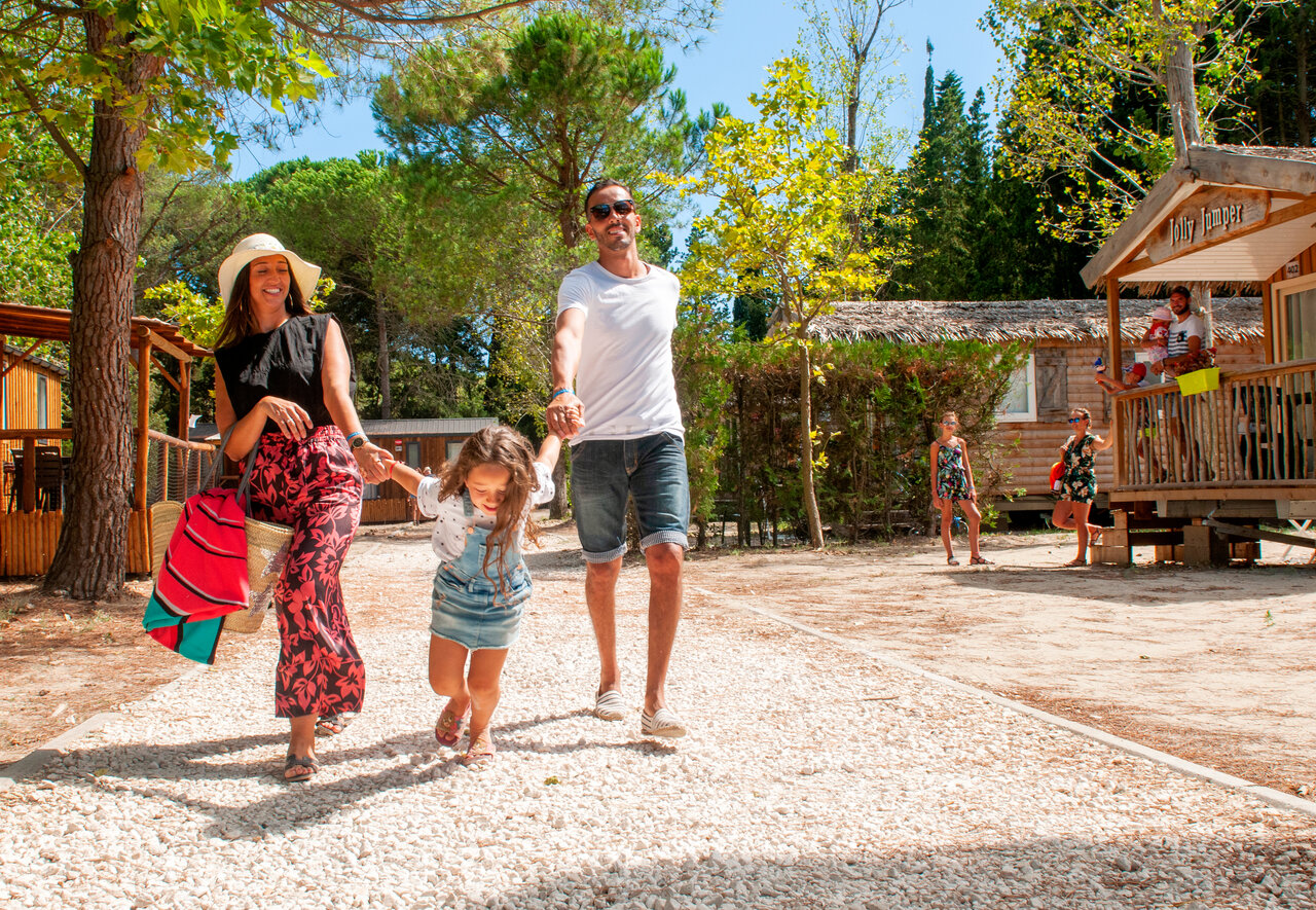 Family walking on gravel path near Mobil-homes, at CAPFUN Or campsite in La Grande Motte (34).