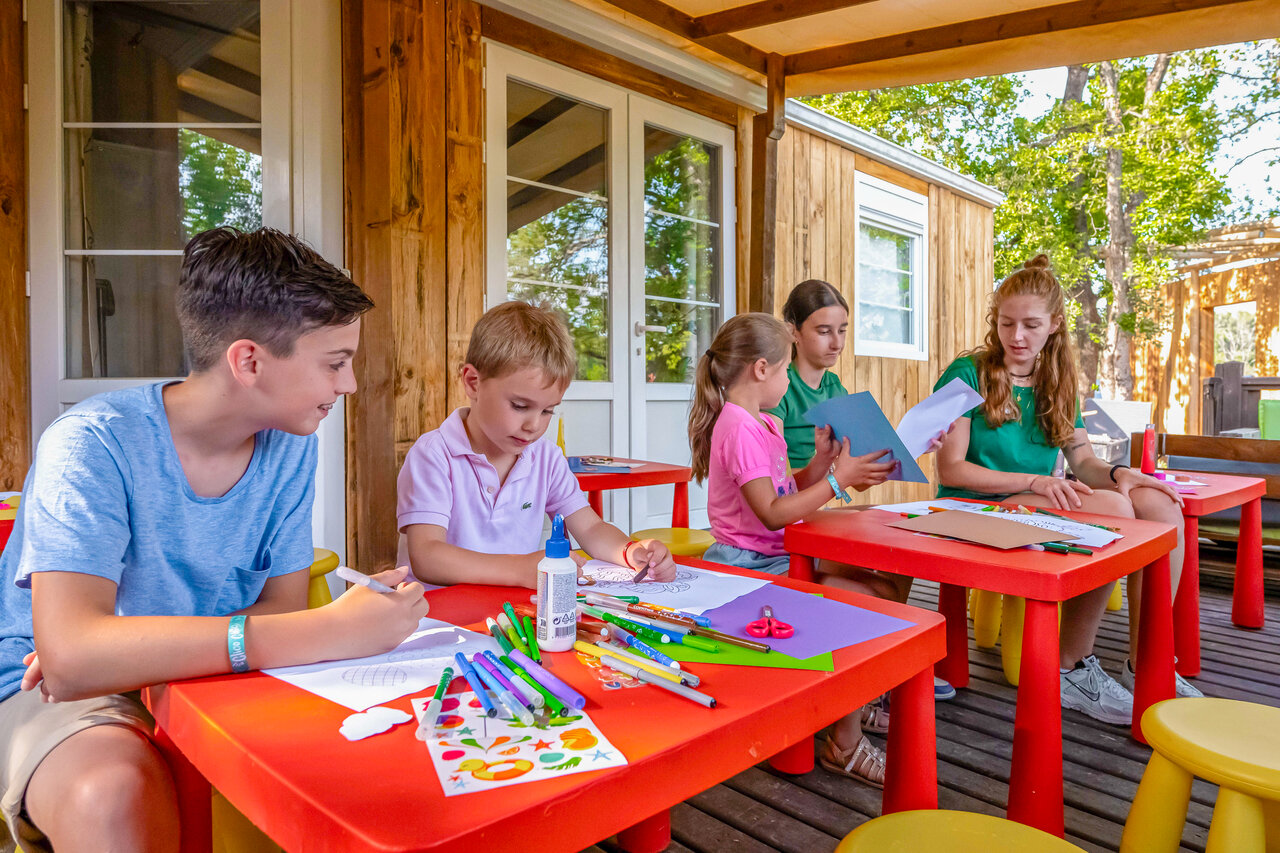 Children enjoying creative workshop on Mobil-home terrace at CLICOCHIC Or�e d'Azur campsite in OPIO (06).