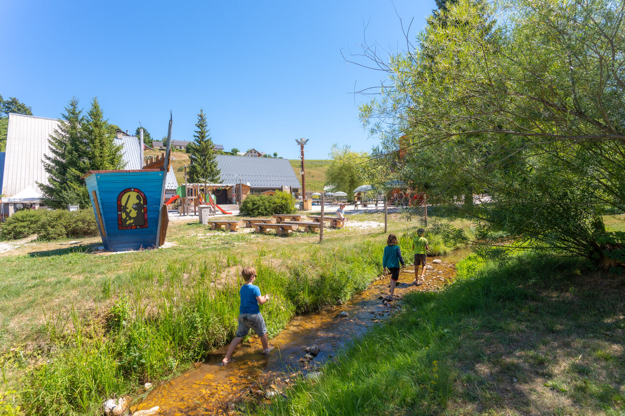 Children playing in stream, playground at CAPFUN Oursi�re campsite in Villard de Lans.