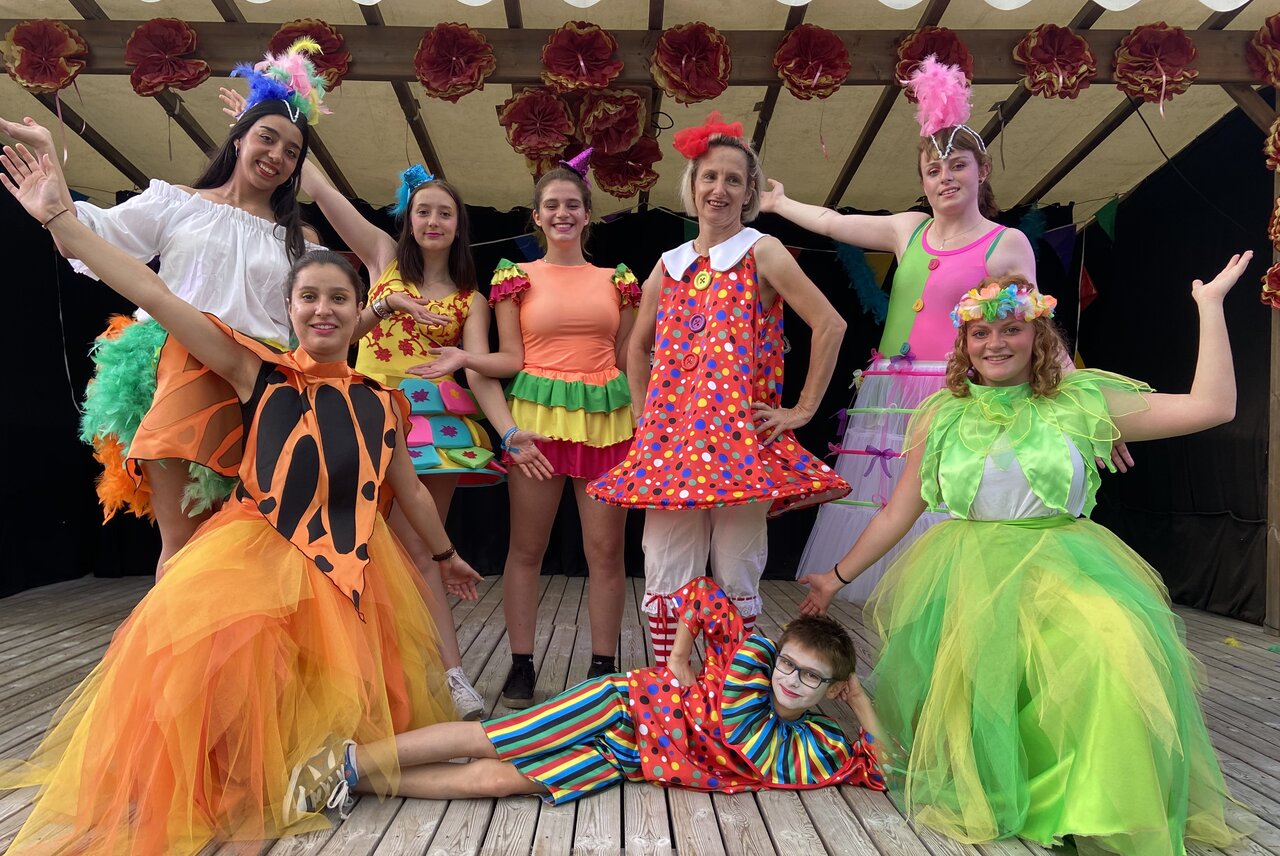 Costumed animation team posing on stage, festive atmosphere at CAPFUN Oursi�re campsite in Villard de Lans (38).