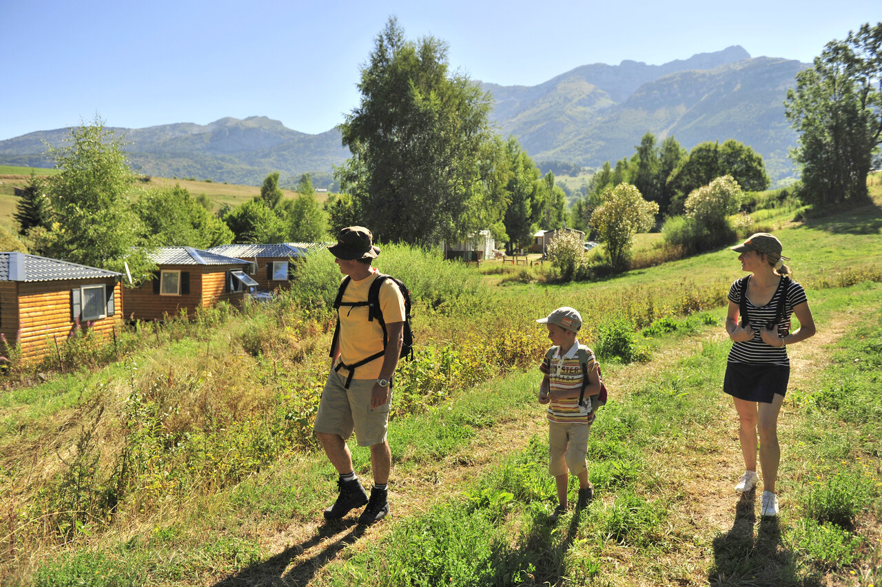 Family hiking near Mobile homes, mountains at CAPFUN Oursi�re campsite in Villard de Lans (38).