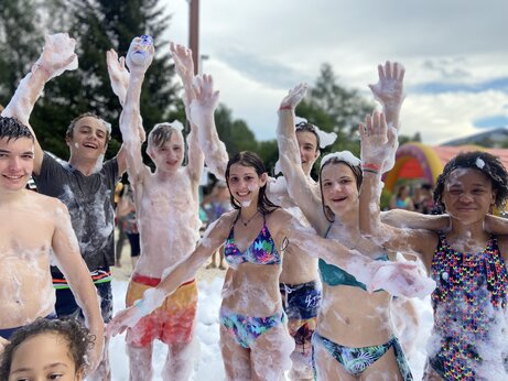 Smiling children and teenagers enjoying a foam party at CAPFUN Oursi�re campsite in Villard de Lans (38).