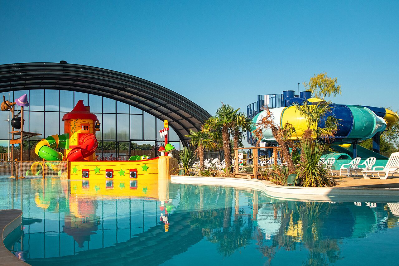Outdoor pool, colorful slides, pirate ship at CAPFUN Pachy campsite, FOSSES LA VILLE.