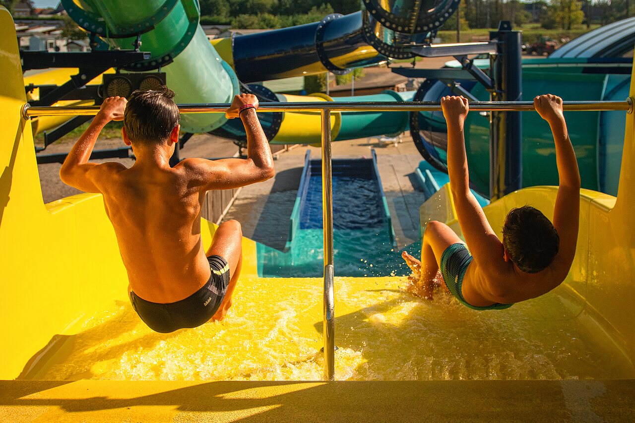 Children on yellow water slides, CAPFUN Pachy campsite pool, FOSSES LA VILLE.