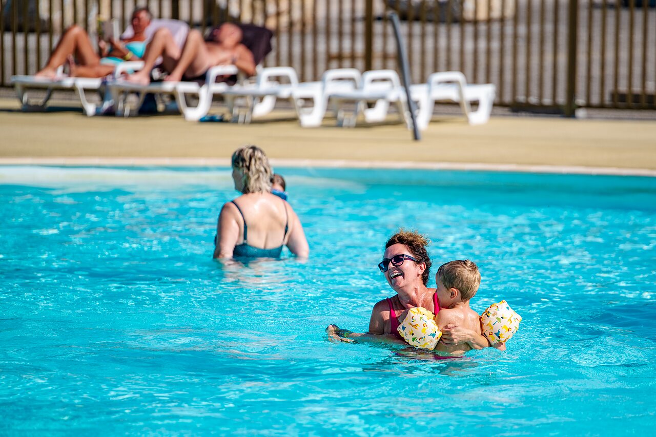 Woman and child with armbands in the swimming pool at CAPFUN Pachy campsite in FOSSES LA VILLE.