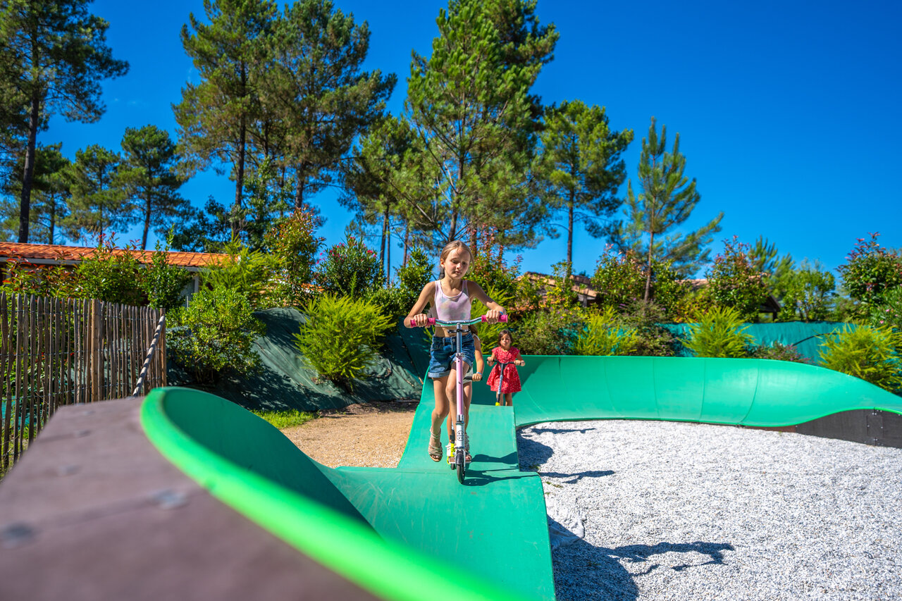 Children playing on a pump track at CAPFUN Paillotte campsite in AZUR (40).