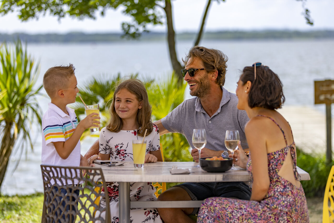Family dining at lakeside restaurant, CAPFUN Paillotte campsite in AZUR (40).