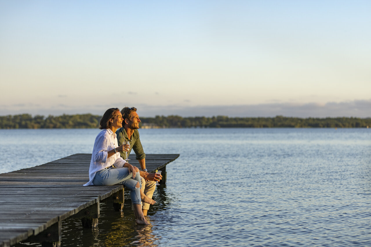 Couple on pier, feet in water at CAPFUN Paillotte AZUR (40).