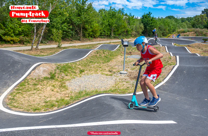 Modern pumptrack with child on scooter at CAPFUN Palais de Gaufrette campsite in R�mering les Puttelange (57).