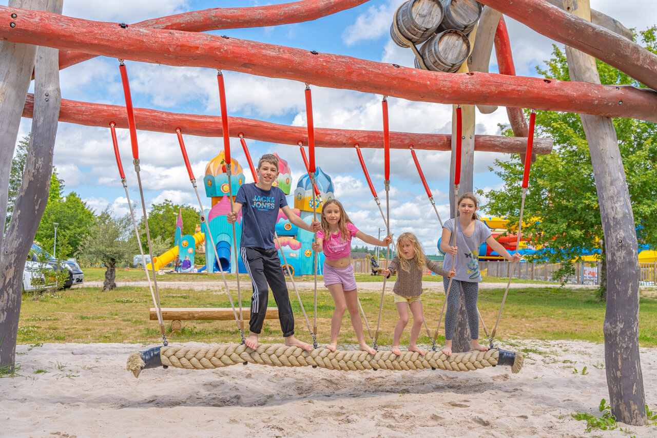 Children on rope swing, playground at CAPFUN Palais de Gaufrette campsite.