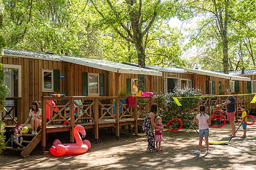 Wooden mobile homes, families playing at CAPFUN Palombi�re, SAINT-NATHALENE (24).