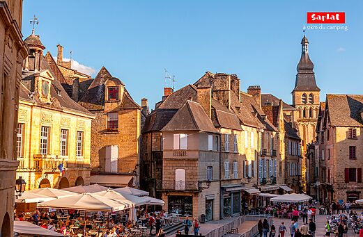 Lively square in Sarlat-la-Can�da with cafe terraces and medieval architecture.