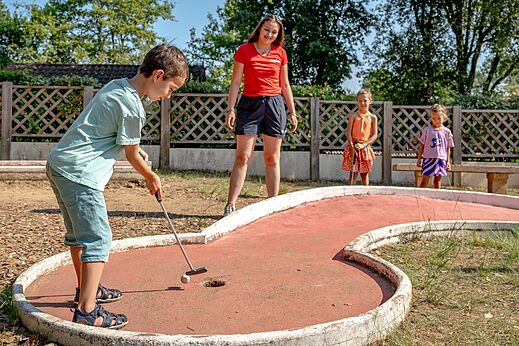 Child playing mini-golf on the course at CAPFUN Palombi�re campsite in SAINT-NATHALENE (24).