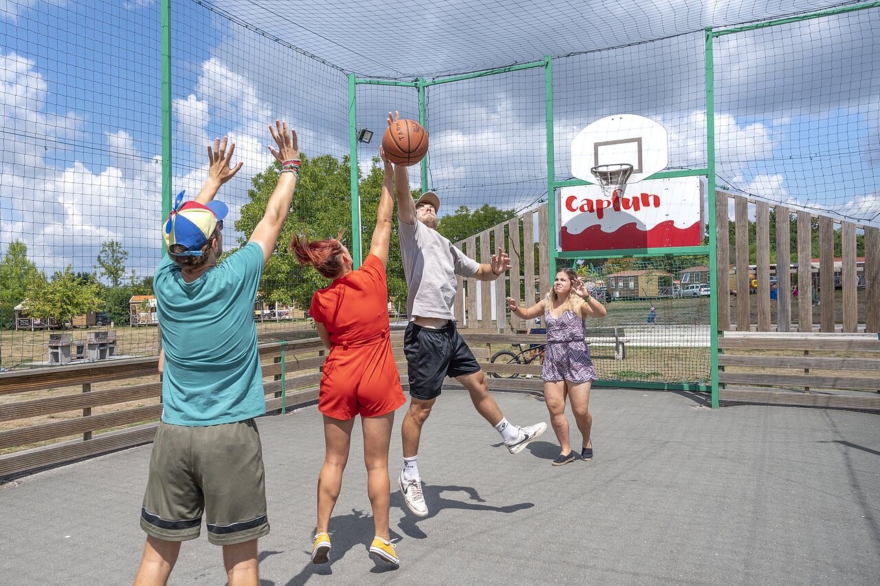 Basketball game on multisport court at CAPFUN Paradis de Bazas campsite in BAZAS (33).