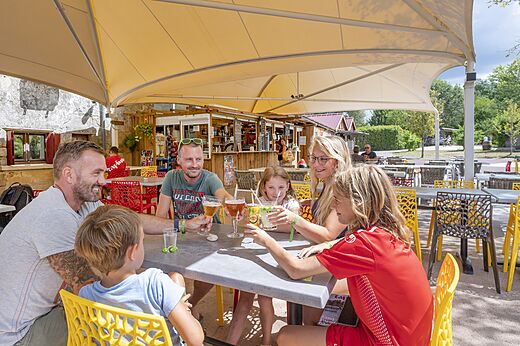 Family toasting at the bar of CAPFUN Paradis de Bazas (33).
