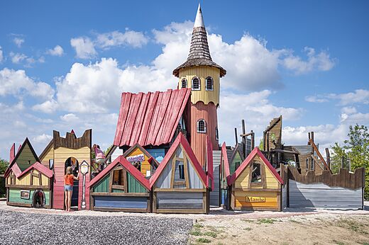 Themed playground with tower and small houses at CAPFUN Paradis de Bazas campsite in BAZAS (33).