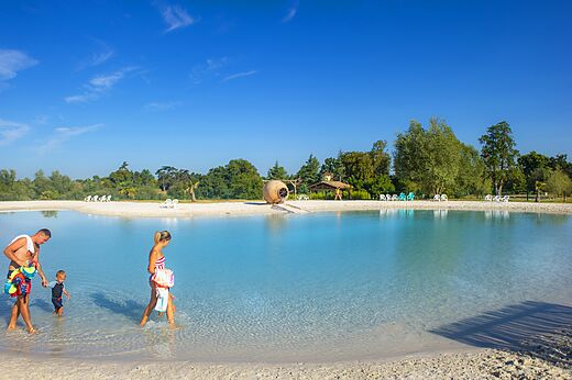Lagoon artificial beach and family at CAPFUN Paradis de Bazas campsite in BAZAS (33).