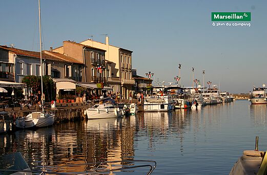 Marseillan harbor with moored boats and lively terraces, Hérault, Occitanie.