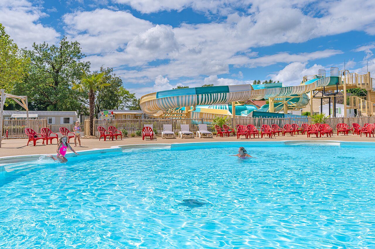 Outdoor swimming pool with giant slide and children at CAPFUN Parc de Paris campsite in Villevaud� (77).