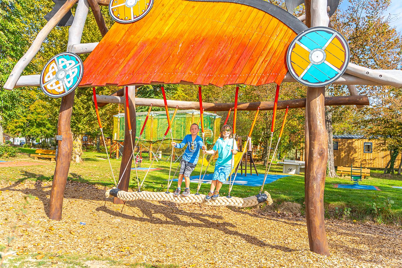 Children having fun on giant swing, playground CAPFUN Parc de Paris (77).