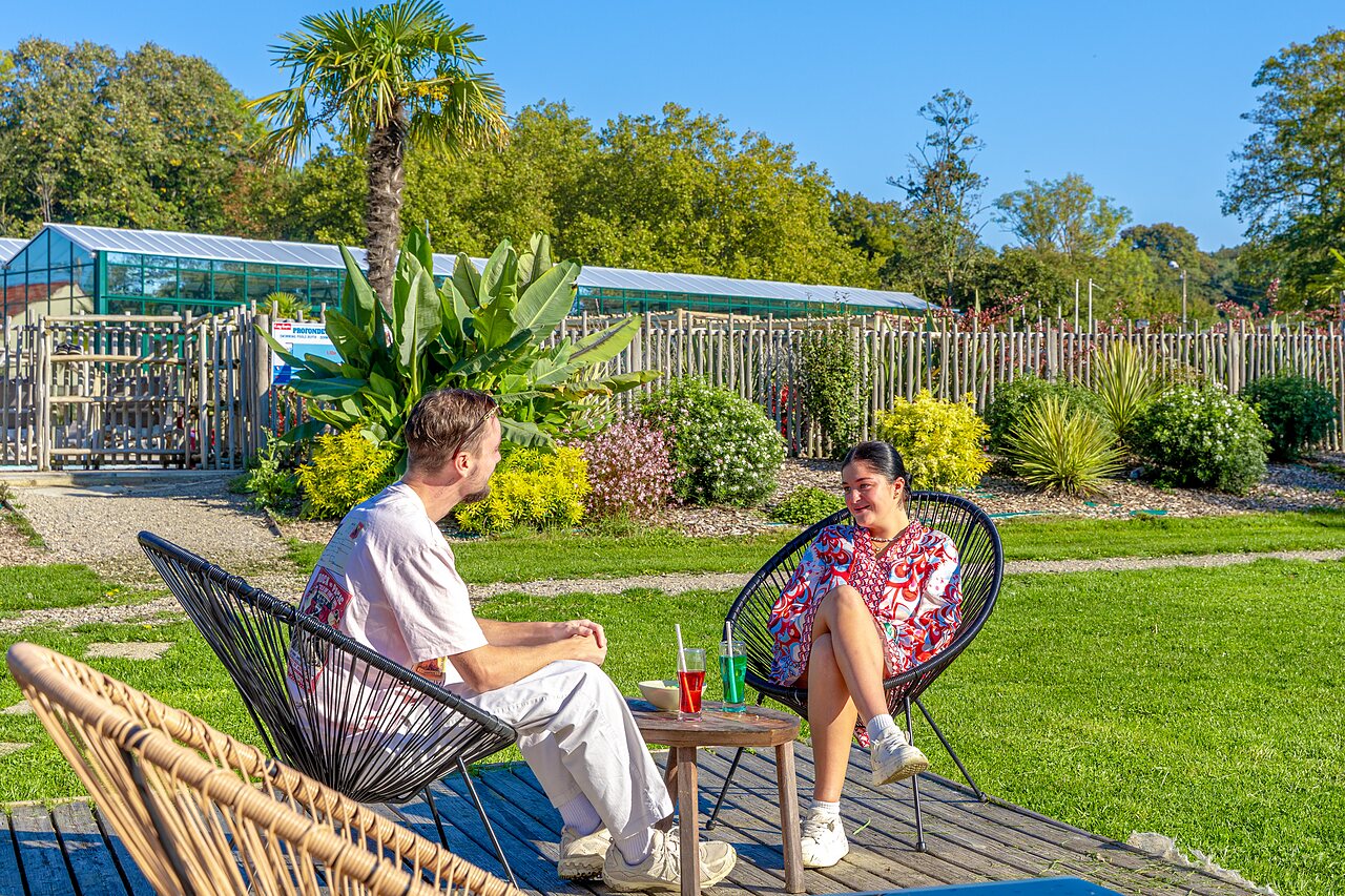 Couple relaxing near the outdoor swimming pool at CAPFUN Parc de Paris campsite in Villevaud� (77).