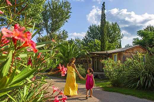 Wooden Mobil-home and lush vegetation at CAPFUN Paris Roussillon campsite in ARGELES SUR MER (66).