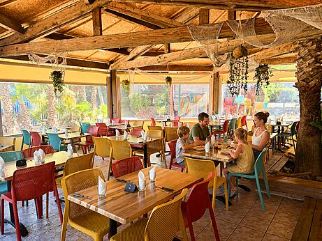 Family restaurant with colorful tables at CAPFUN Paris Roussillon campsite in ARGELES SUR MER (66).