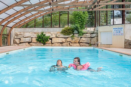 Covered swimming pool, children happily swimming at CAPFUN Pergola campsite in Marigny (39).