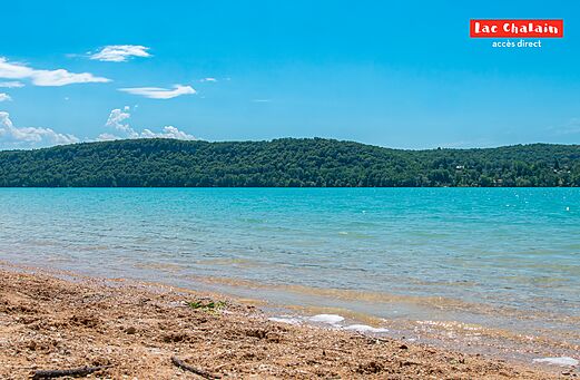Sandy beach and turquoise water of Lac Chalain, in Jura.