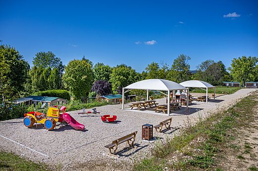 Colorful playground with slide and swing at CAPFUN Pergola campsite in Marigny (39).