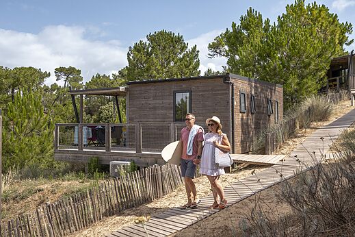 Wooden Mobil-home, couple on sandy path at CLICOCHIC Petit Bec campsite in St Hilaire de Riez.