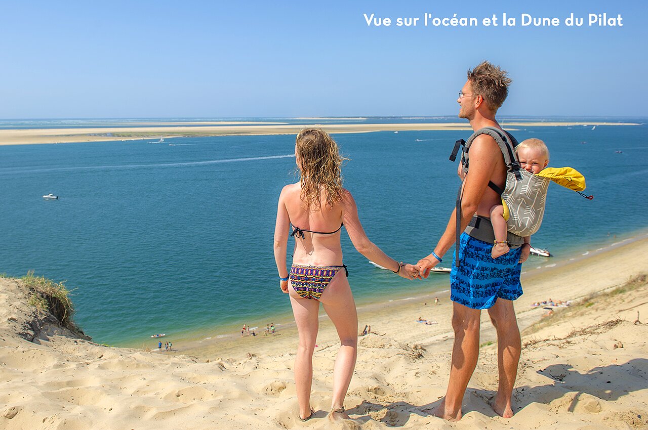 Couple with baby admiring view of Arcachon Bay from Dune du Pilat, a must-visit spot near the campsite.