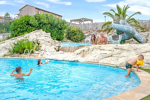 Outdoor swimming pool with slide and family enjoying a swim at camping CLICOCHIC Petit Nice in PYLA SUR MER (33).