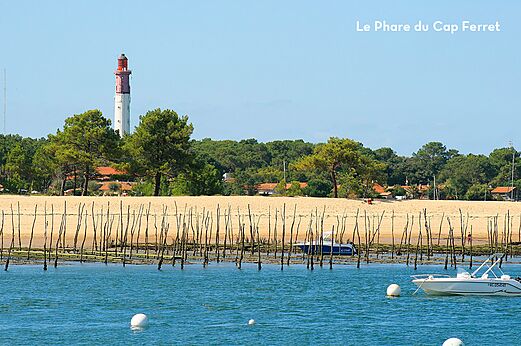 Cap Ferret lighthouse, beach and boats on Arcachon Bay.