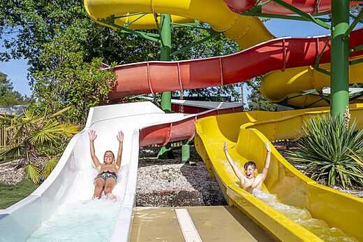 Happy children on colorful waterslides at CAPFUN Pin�da campsite in CAZAUX (33).