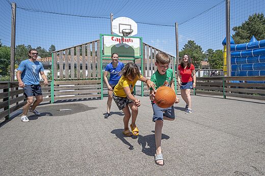 Multisport court with children playing basketball at CAPFUN Pin�da campsite in CAZAUX (33).