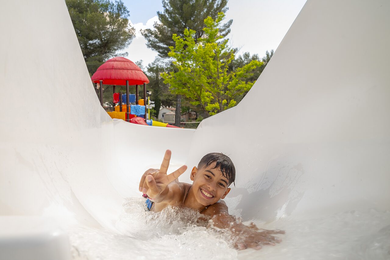Smiling child on water slide at CAPFUN Pin�des du Luberon campsite in PERTUIS (84).