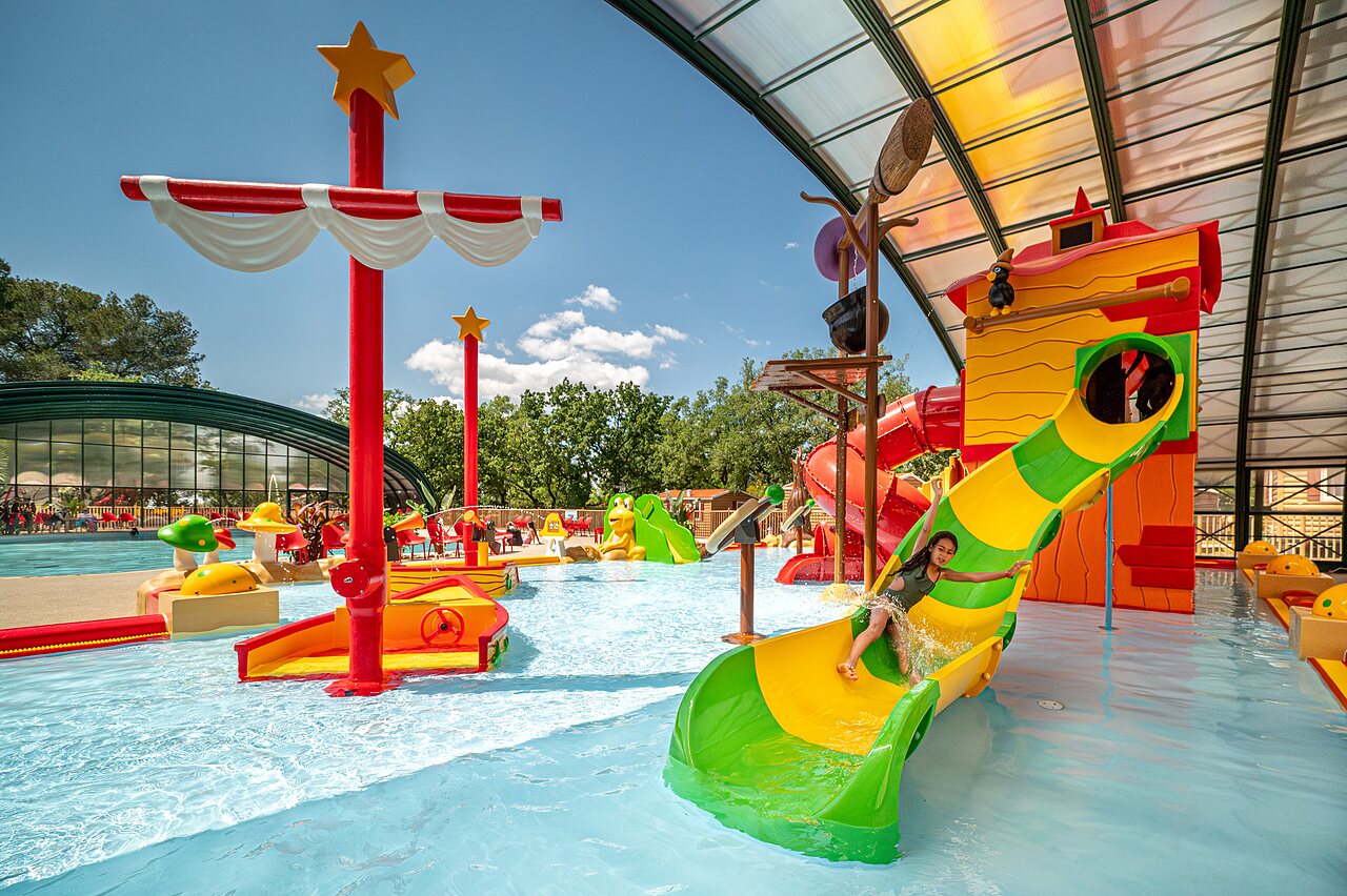 Child on colorful water slide, water games at CAPFUN Pin�des du Luberon campsite in PERTUIS (84).