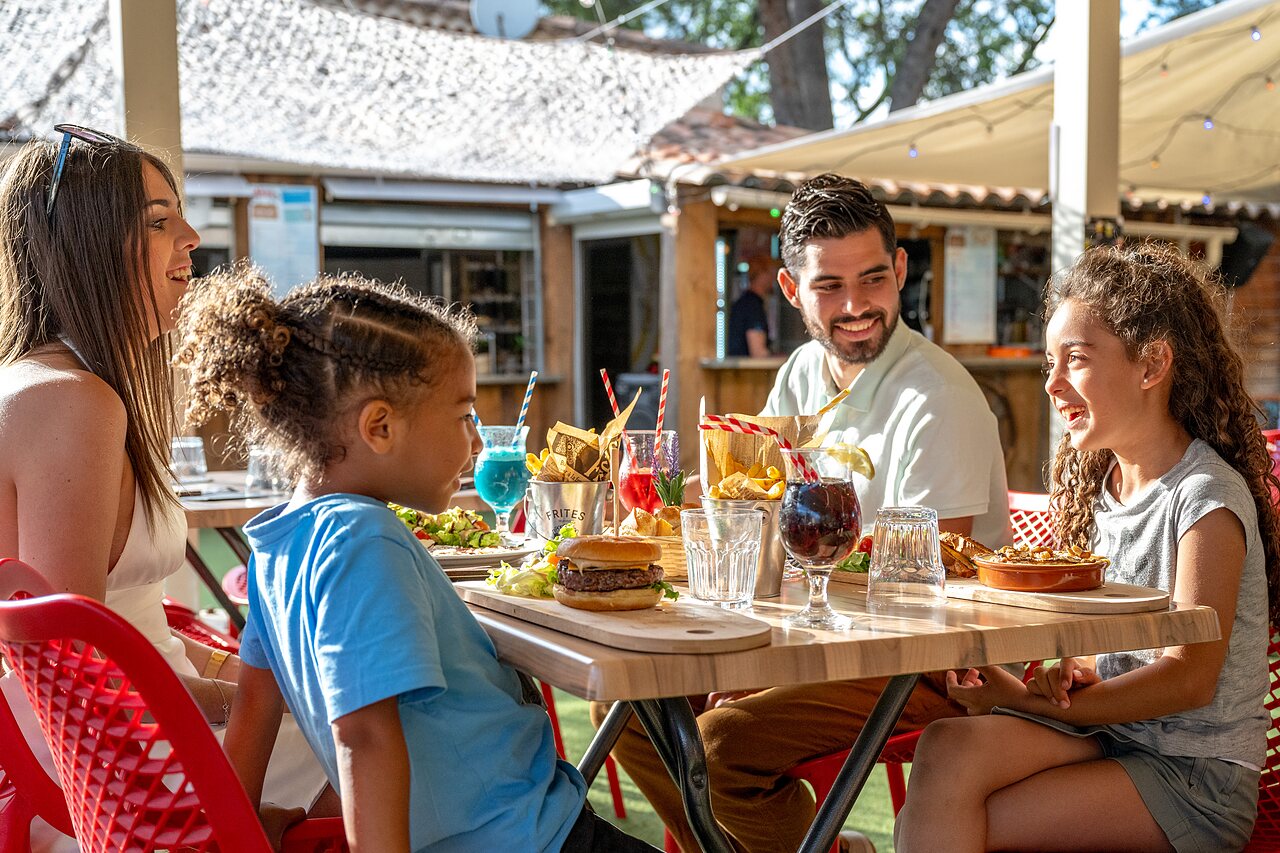 Smiling family dines at CAPFUN Pin�des du Luberon campsite restaurant, PERTUIS (84).