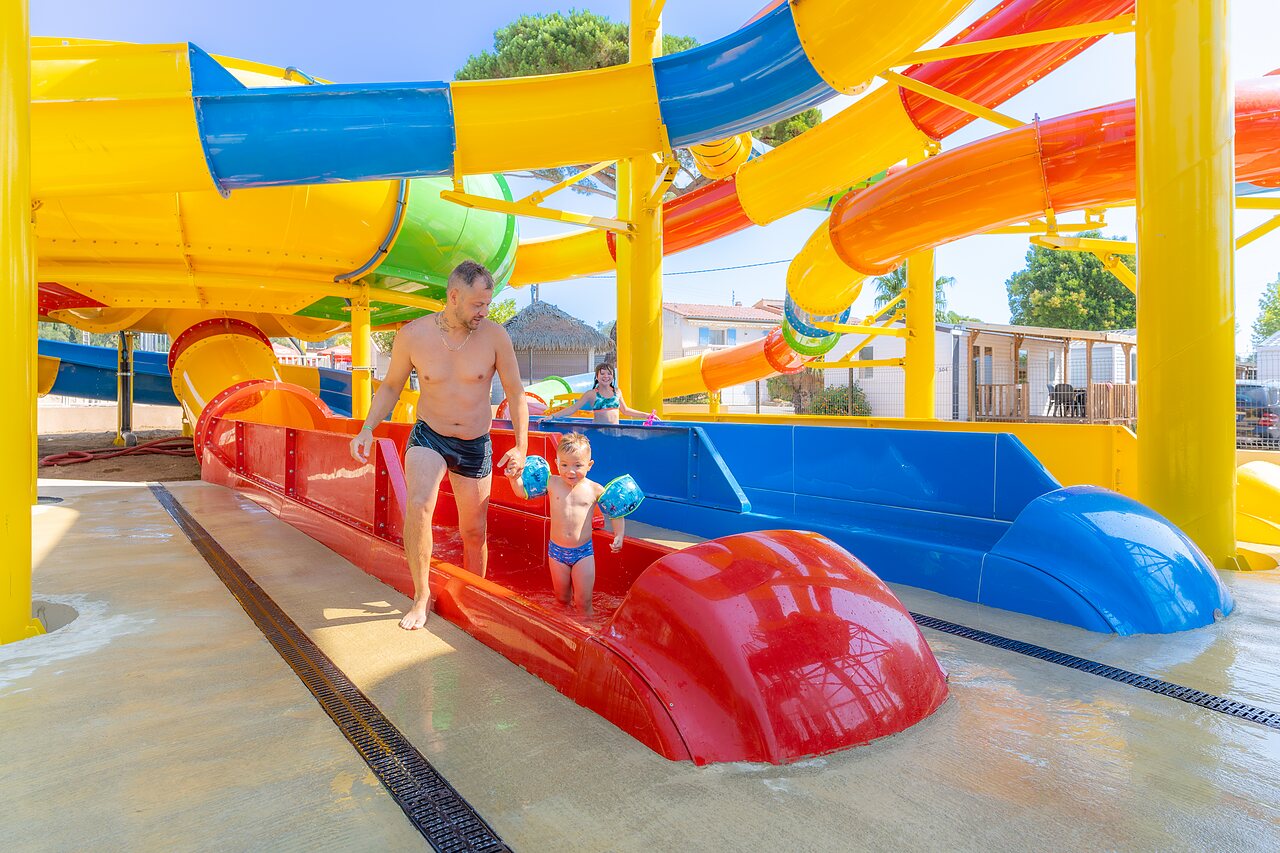 Father and child on colorful water slides at CAPFUN La Pin�de de Grimaud (83).