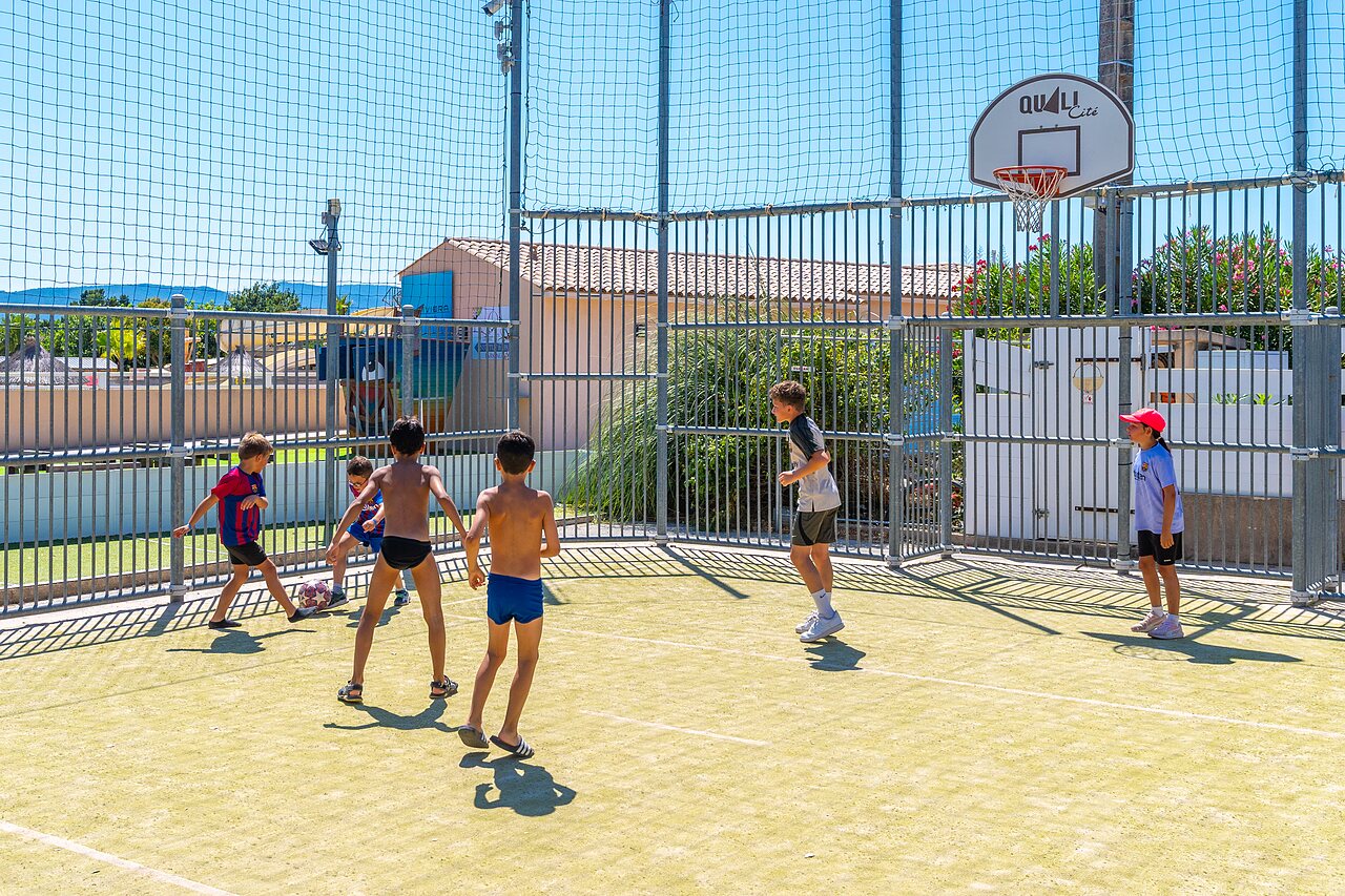 Children playing football on multi-sport court at CAPFUN La Pin�de de Grimaud (83).