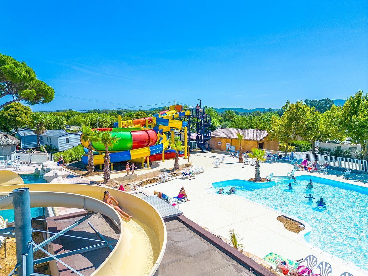 Colorful water slides, outdoor pool at CAPFUN La Pin�de de Grimaud campsite (83).