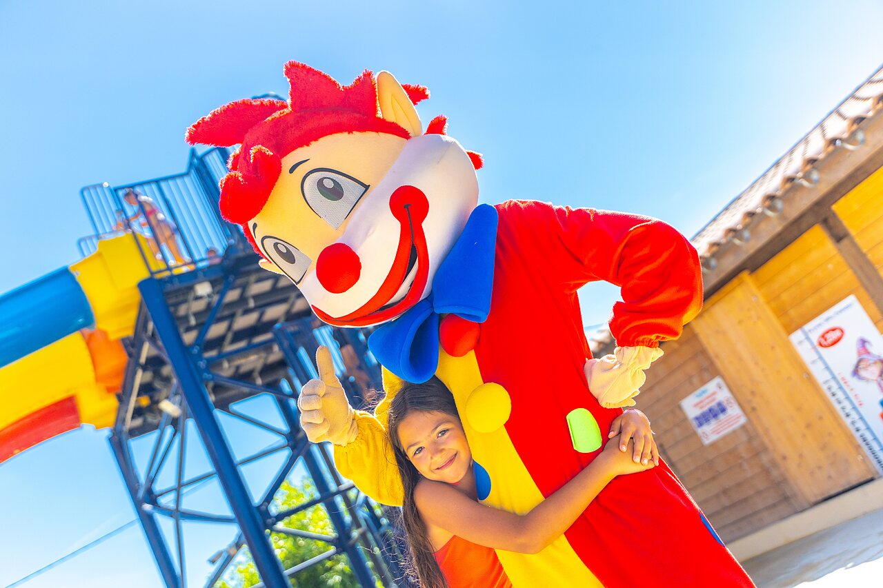 Mascot and smiling child, water slide at CAPFUN La Pin�de de Grimaud campsite.