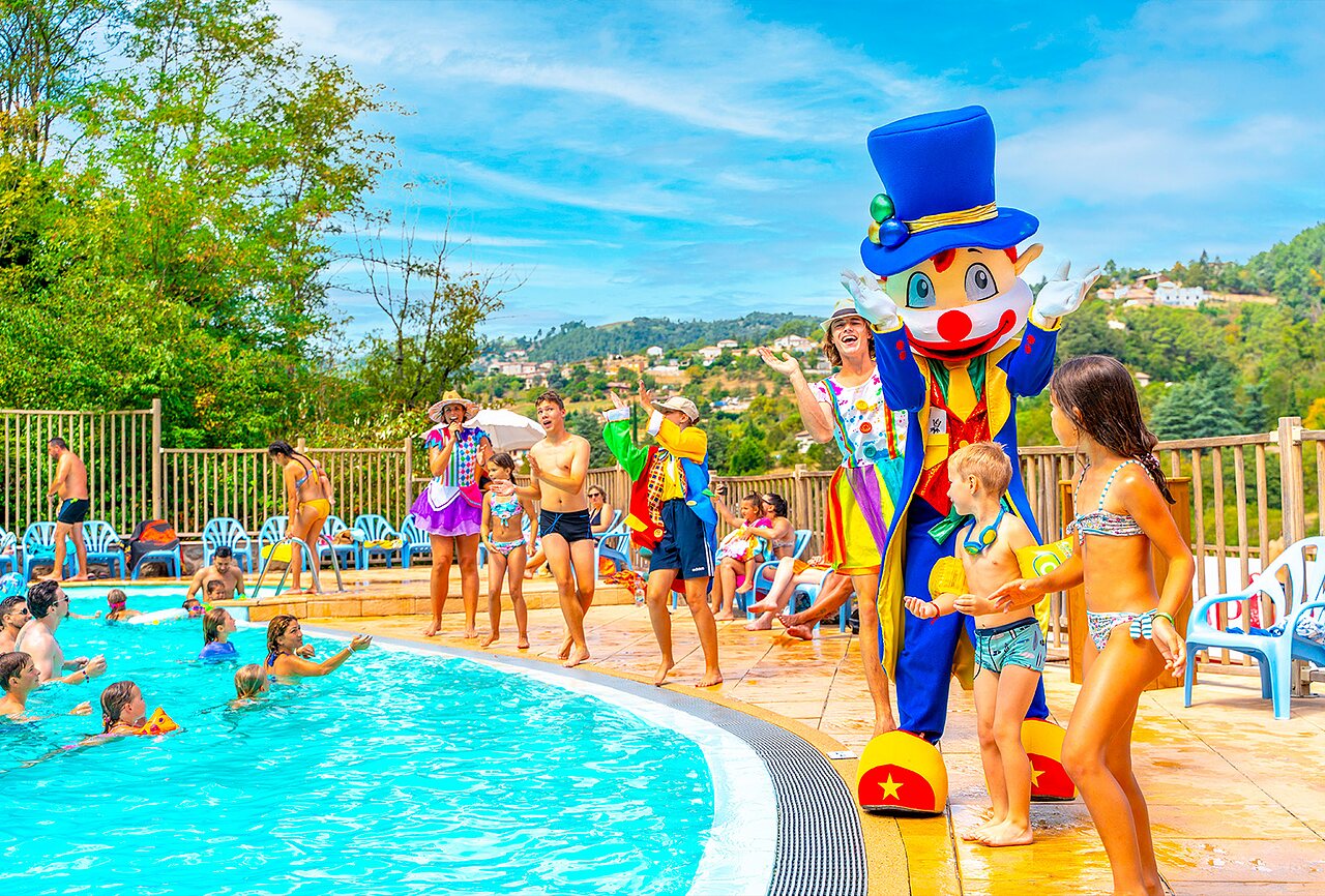 Outdoor swimming pool with entertainment and mascot at CAPFUN Plantas campsite, SAINT VINCENT DE DURFORT (07).