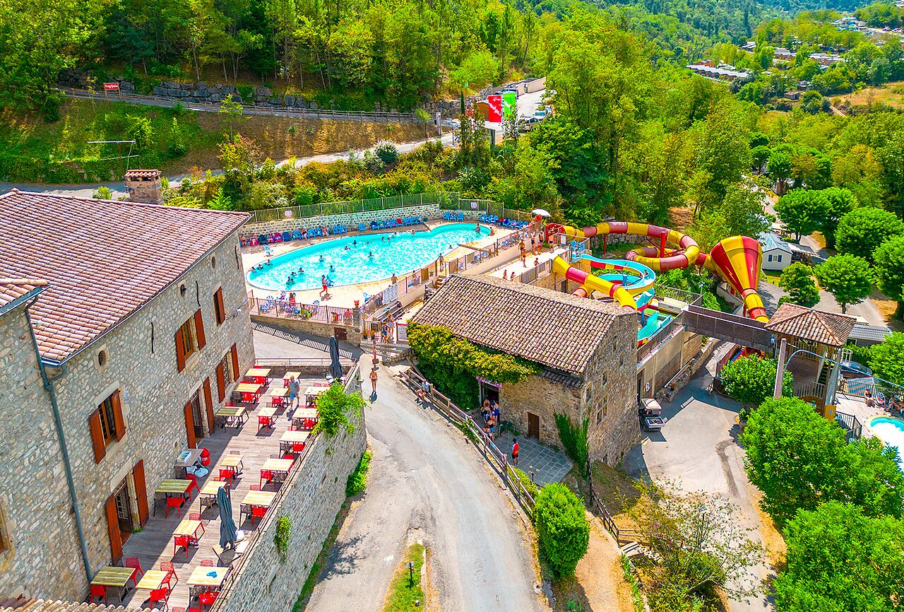Outdoor pool, water slides and restaurant at CAPFUN Plantas campsite (07).