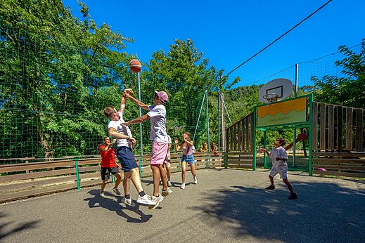 Multi-sport court with basketball game at CAPFUN Plantas campsite in SAINT VINCENT DE DURFORT.