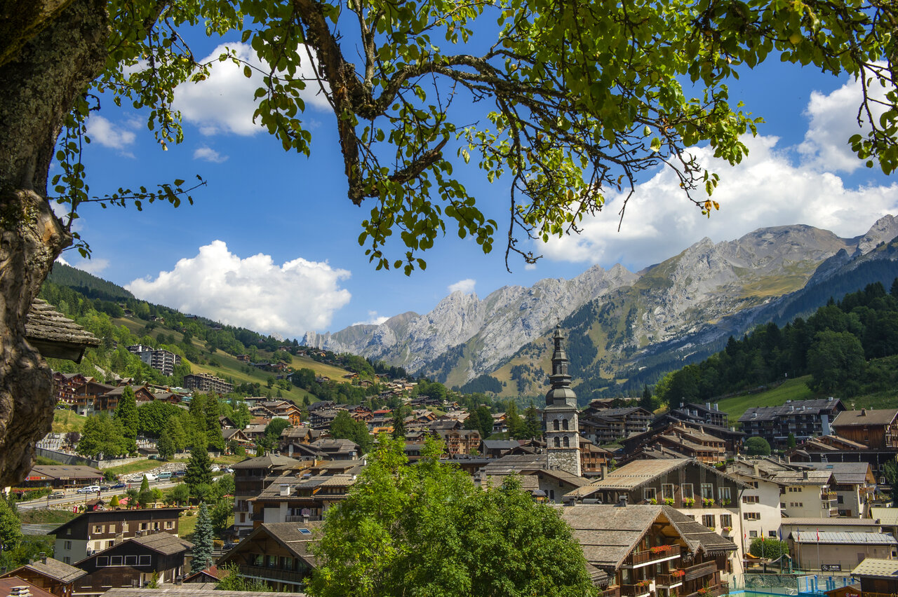 Traditional mountain village near La Clusaz, surrounded by green Alpine peaks.