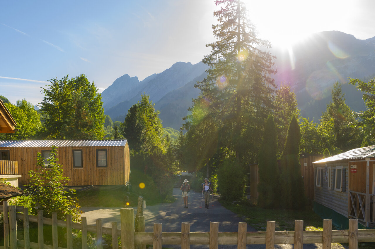 Wooden accommodations, hikers in mountains at CAPFUN Plan du Fernuy campsite in LA CLUSAZ.