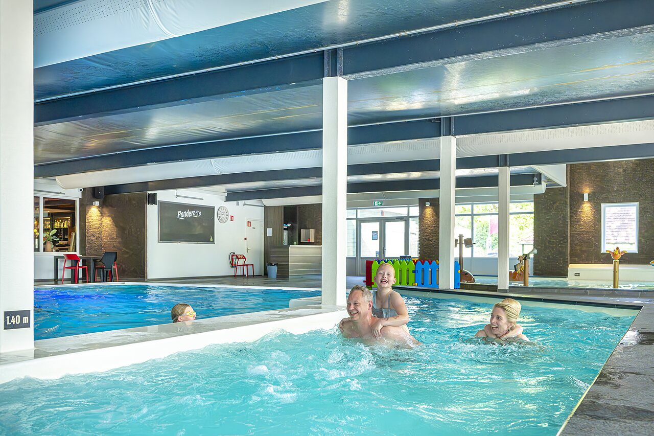 Indoor pool with jacuzzi and water games, family at CAPFUN Ponderosa in Ulicoten.